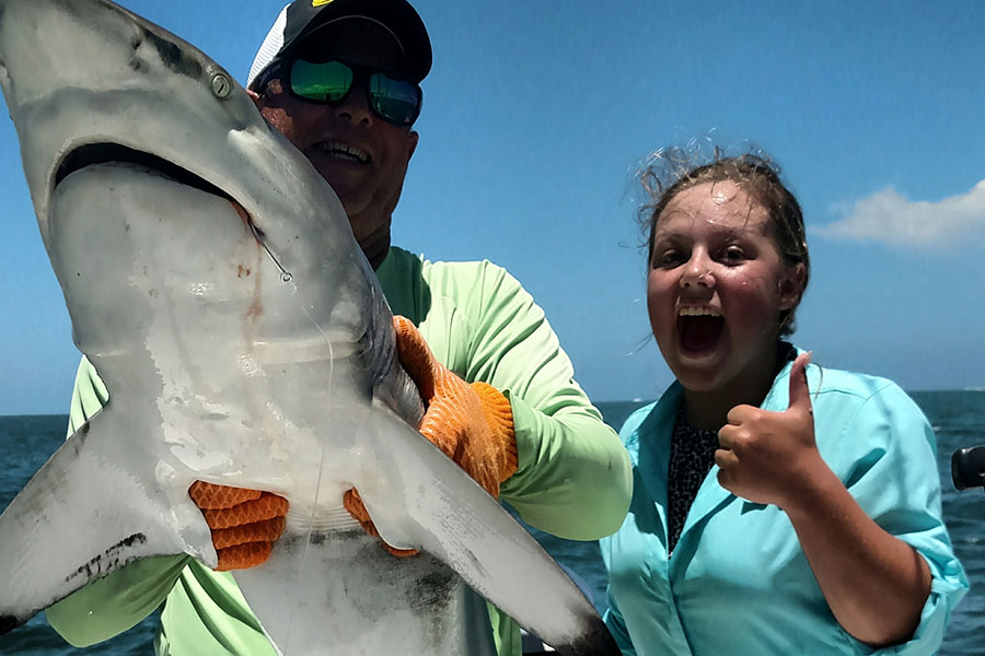 Happy angler with a shark caught with Capt. Greg Hildreth