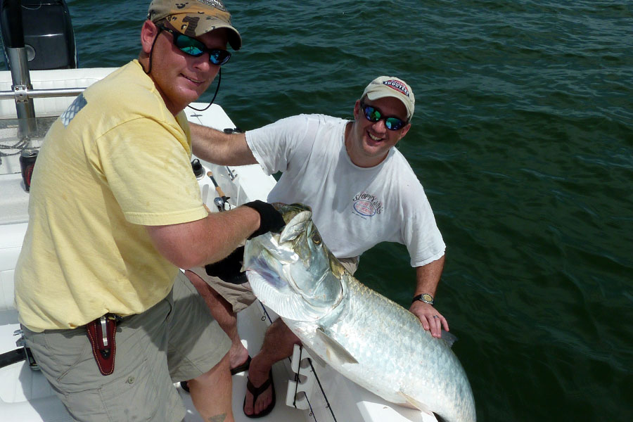 Anglers releasing a tarpon beside the boat