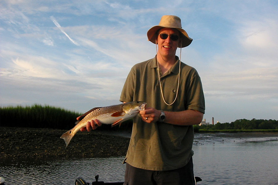 Angler with a redfish at sunset in the marsh