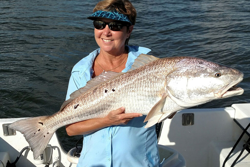 Angler holding a bull redfish aboard a Georgia charter boat