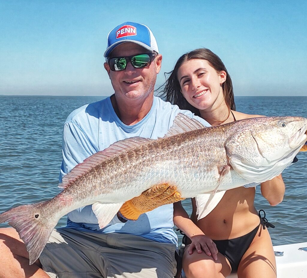 Two anglers holding a bull redfish together